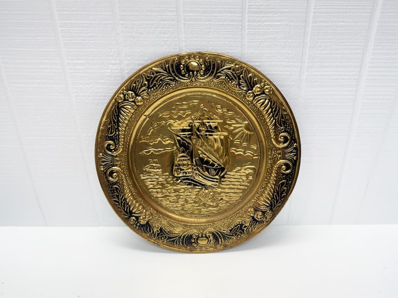 Hanging brass charger with embossed ship design