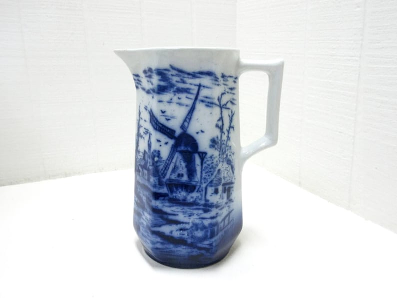 Blue and white transferware pitcher with sailboat scene